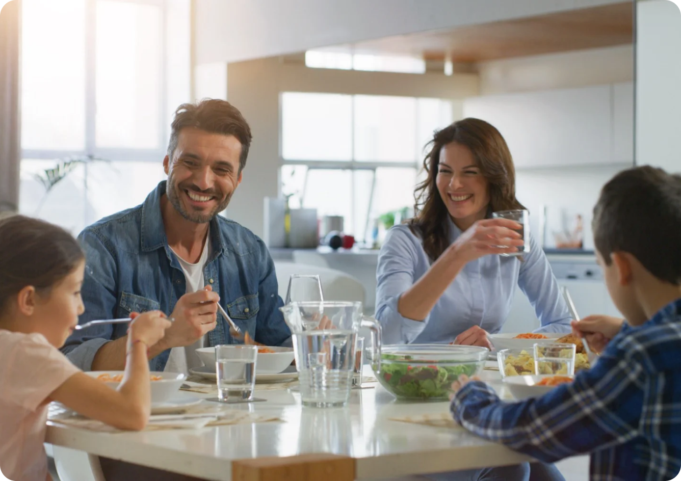 Uma familia comendo sorridente na mesa de jantar